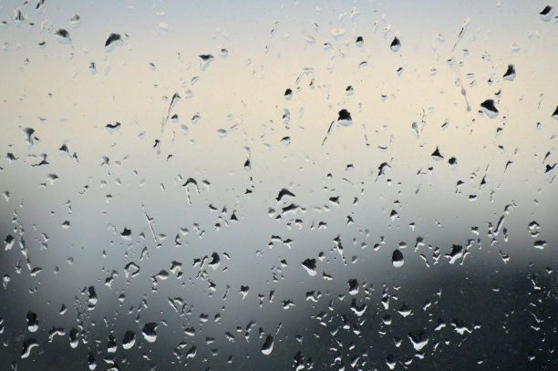 抽象的图片背景。雨滴落在窗户上。选择性聚焦，多雨的城市背景。水滴在玻璃上。雨天，模糊的墙纸图片下载