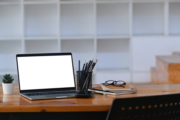 模拟笔记本电脑与白色屏幕，书和铅笔持有人木制桌子。图片下载