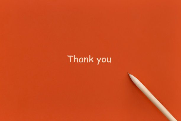 用钢笔在红色的背景上写上谢谢。前视图。平的。图片下载