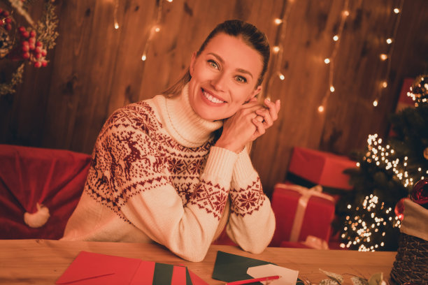 照片甜美漂亮的年轻女士穿着印花套衫写圣诞愿望清单微笑在室内房间家房子图片下载