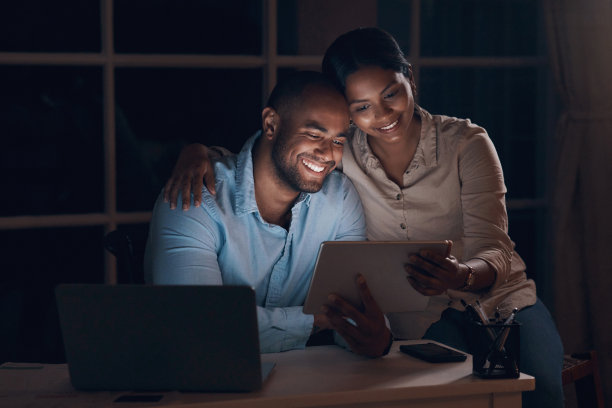 一对年轻夫妇在晚上一起使用平板电脑的照片图片下载