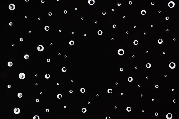 扭动的眼睛塑料玩具在黑色的背景图片下载