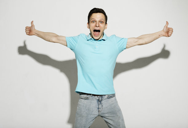 快乐的年轻英俊的男人手势和保持嘴巴张开，而站在白色的背景图片下载