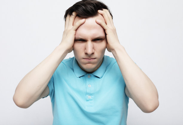 紧张不安的人遭受强烈的偏头痛孤立的白色灰色背景图片下载
