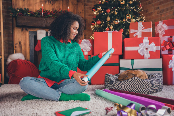 完整的照片年轻的非洲妇女快乐积极的微笑纸礼物圣诞节假期冬天动物在室内图片下载