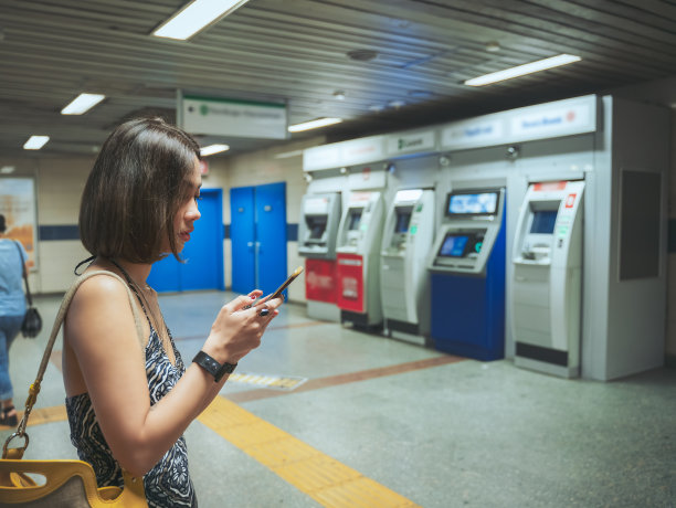 地铁乘客在提款机前使用手机图片下载