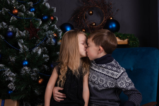 圣诞树旁迷人的金发小男孩和小女孩。兄弟姐妹庆祝新年图片下载