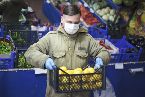 戴着蓝色保护手套的男人拿着一只柠檬图片下载