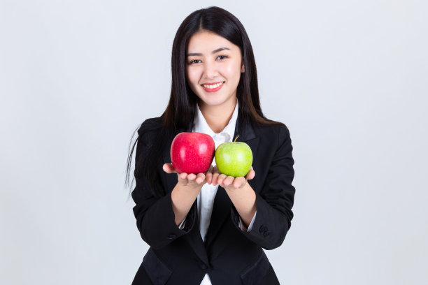漂亮的女人捧着青苹果和红苹果，吸引亚洲人喝饮料的智慧，人们的生活理念。图片下载