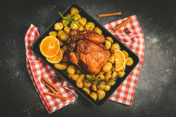 鸡肉，土豆，香草，橘子和肉桂条放在烤盘里。图片下载