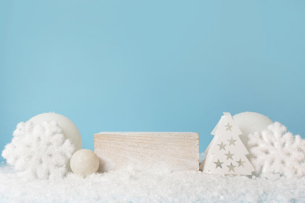 白色立方体底座上的雪花，冬天喜庆的蓝色背景。灯光圣诞现场与讲台。化妆品及美容产品陈列。站在白色的新年装饰图片下载