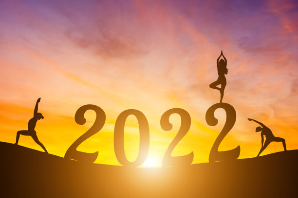 新年快乐数字2022，晨曦中练瑜伽的女子晨曦越过地平线背景，健康和新年快乐的概念。图片下载