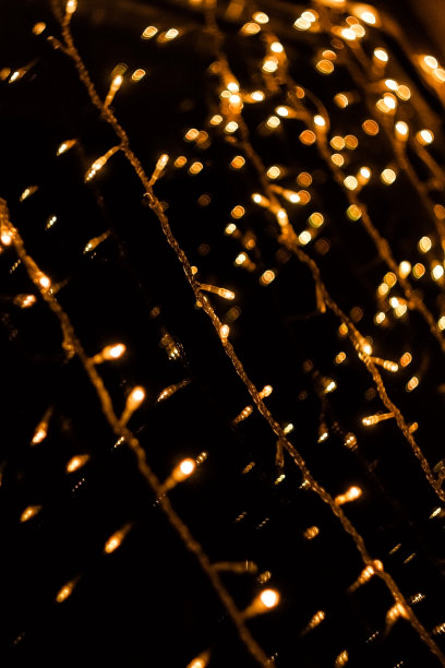 节日的窗户装饰在黄昏。圣诞灯。花环发出黄色的光。模糊的照片图片下载