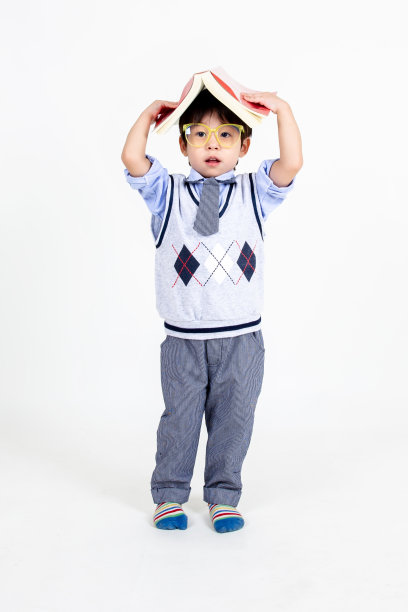 小男孩戴着眼镜，带着白色背景的书，教育理念。图片下载