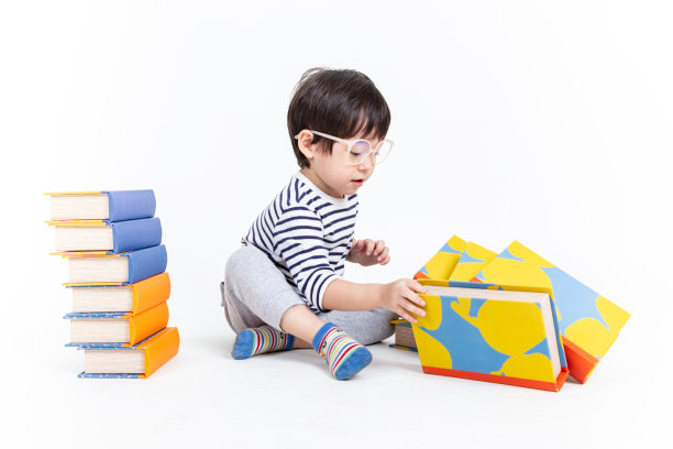 小男孩戴着眼镜，带着白色背景的书，教育理念。图片下载