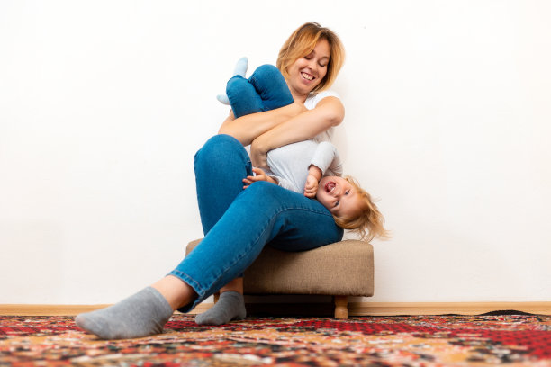 一位快乐的母亲和她的孩子一起在家里玩耍。低角度的观点图片下载