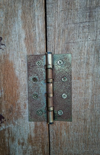 锈迹斑斑的棕色门铰链在木板上图片下载