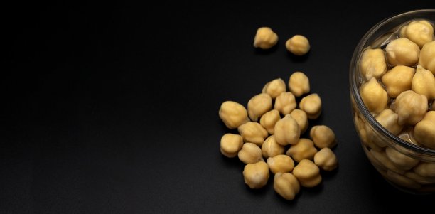 鹰嘴豆在黑色背景的水的杯子II图片下载