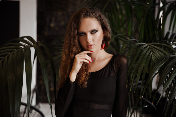 一个迷人的红头发卷发女孩的肖像，穿着黑色皮夹克图片下载