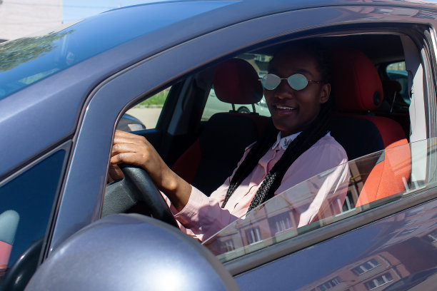 一个戴着墨镜坐在车里的年轻女人。一个女商人在车里图片下载