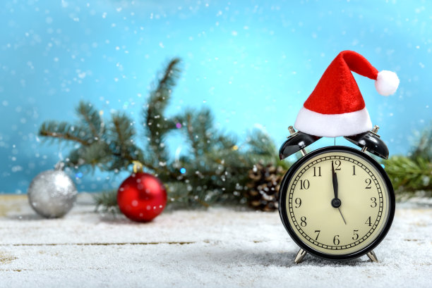 闹钟上有圣诞老人的帽子素材图片