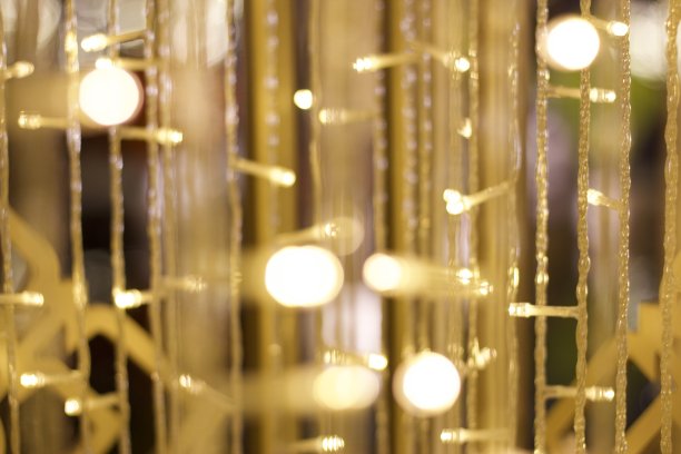 选择性聚焦放大照片的小装饰灯与其他美丽的童话般的灯的散焦临近年底的假期，圣诞节或新年。图片下载