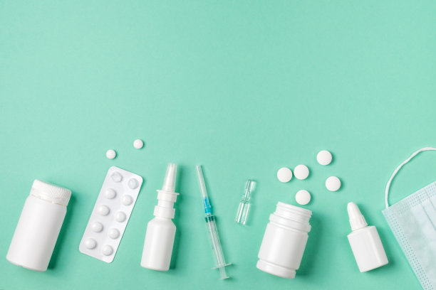 医学概念，平躺在绿色背景上。复制的空间。药丸，鼻喷雾剂，滴剂，绿色的注射器，俯视图图片下载