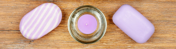 薰衣草香皂和香薰蜡烛放在木制背景上。宽的照片。图片下载