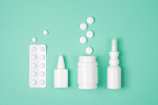医学概念，平躺在绿色背景上。药片，鼻喷雾剂，绿色滴剂，俯视图图片下载