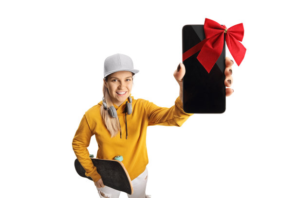 女青少年与耳机和滑板持有智能手机与红色蝴蝶结在相机前图片下载