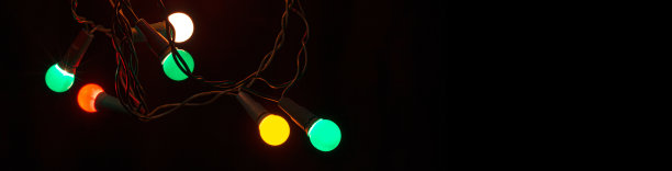 圣诞彩灯在黑色的背景。有选择性的重点。新年，装饰和假日概念照片。图片下载