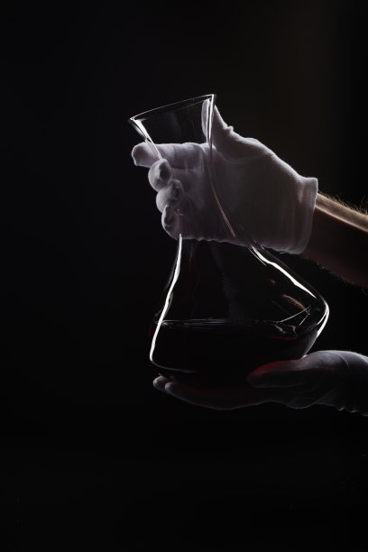 男性手与酒瓶在黑色背景图片下载