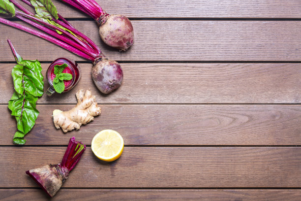 红甜菜根，姜和柠檬冰沙在木制背景。自制的排毒饮料图片下载