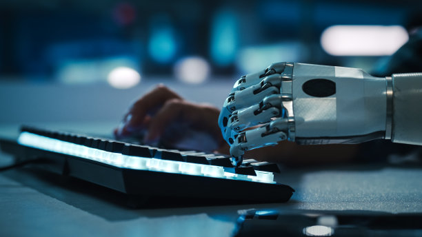 特写的手:残疾人程序员使用假肢臂在背光电脑键盘上工作。专业快速和自然使用肌电仿生手类型的电子商务软件图片下载