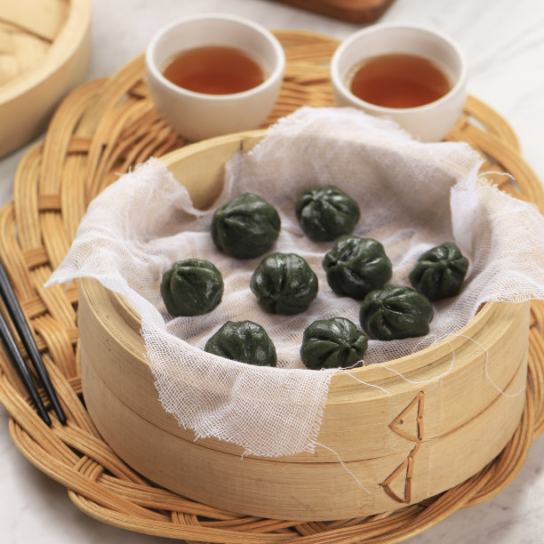 绿艾叶是一种填满蜂蜜和芝麻酱的球形年糕，是中秋节的传统糕点。上竹蒸笼图片下载