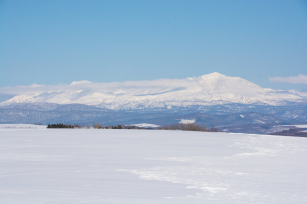 在一个阳光明媚的早春，雪地和雪山图片下载