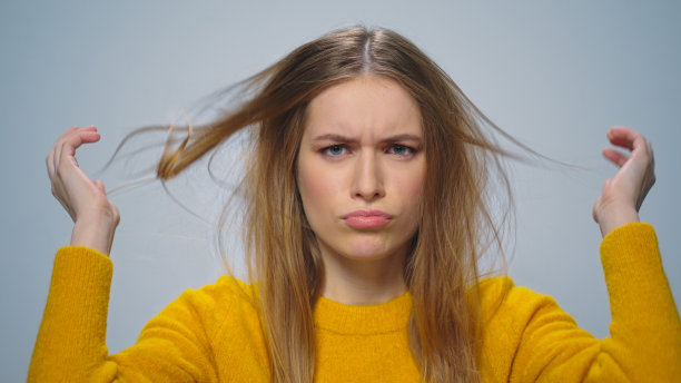 肖像聚焦有吸引力的女人改善外观在灰色背景图片下载