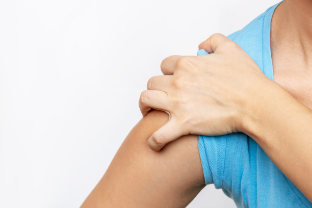 肩膀受伤，手臂疼痛，神经痛。一个手里拿着肩膀的年轻女子图片下载