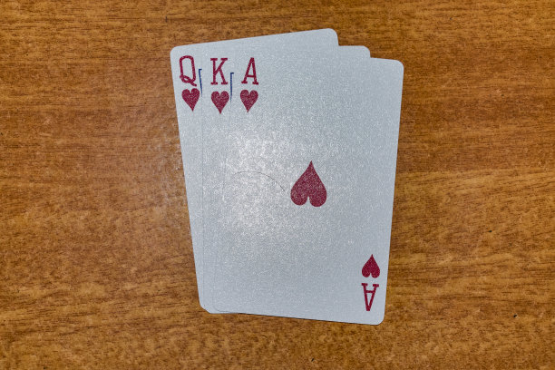 一套扑克牌的A、k和红心的颜色，按顺序放在桌上。图片下载