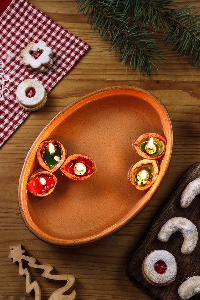 坚果壳和蜡烛漂浮在水面上。传统的圣诞活动图片下载