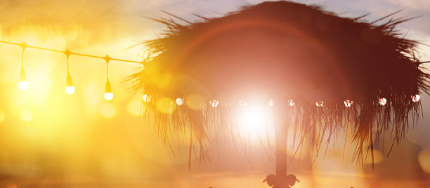 模糊的散光在日落与黄色串灯装饰在海滩餐厅图片下载