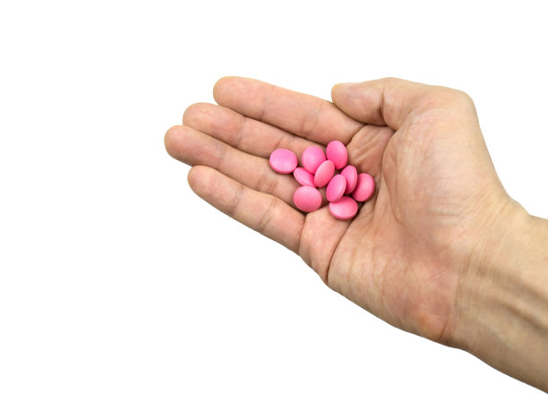 粉色药丸药手孤立的白色背景与剪影路径特写。图片下载