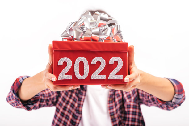 白底的年轻女子用写着“2022”的红色礼盒遮住了脸。这个女孩穿着牛仔裤、衬衫和白色t恤。2022年新年的概念图片下载