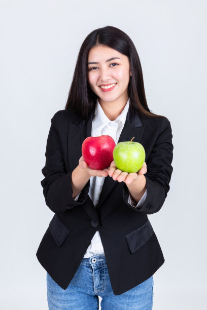 漂亮的女人捧着青苹果和红苹果，吸引亚洲人喝饮料的智慧，人们的生活理念。图片下载