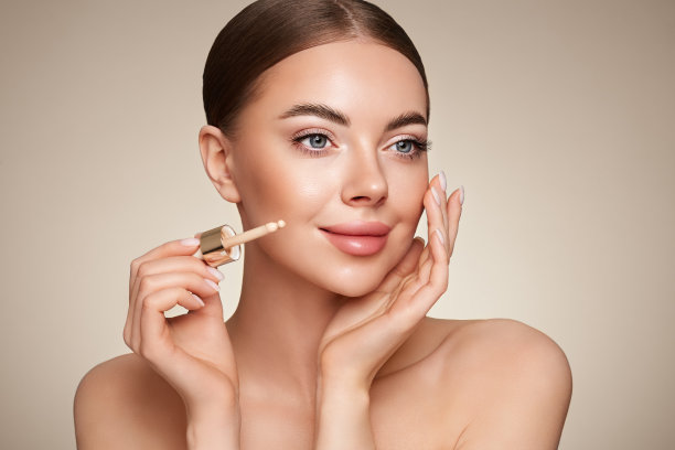 用粉底瓶描绘美丽的年轻女子图片下载