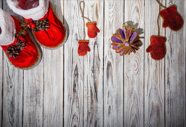 红色圣诞老人靴子，松果和圣诞球在白色木制背景。手工制作，文本复制空间图片下载