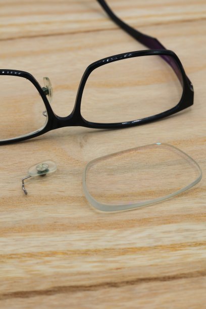 桌子上的镜片和去掉鼻垫的碎眼镜图片下载