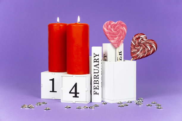 情人节紫色趋势背景。2 .燃烧的红烛，一个万年历块与2月14日的日期和甜蜜的爱情焦糖心图片下载