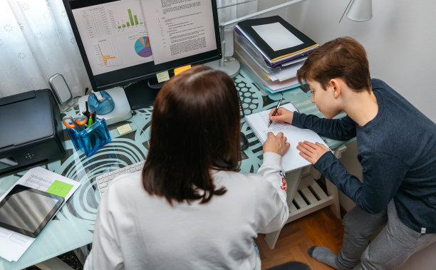 妈妈一边远程工作一边帮儿子做作业图片下载