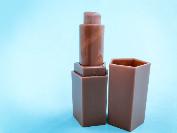 哑光唇膏在蓝色明亮的哑光背景。米色心形口红，柔和的棕色阴影。裸色，美丽的唇妆图片下载